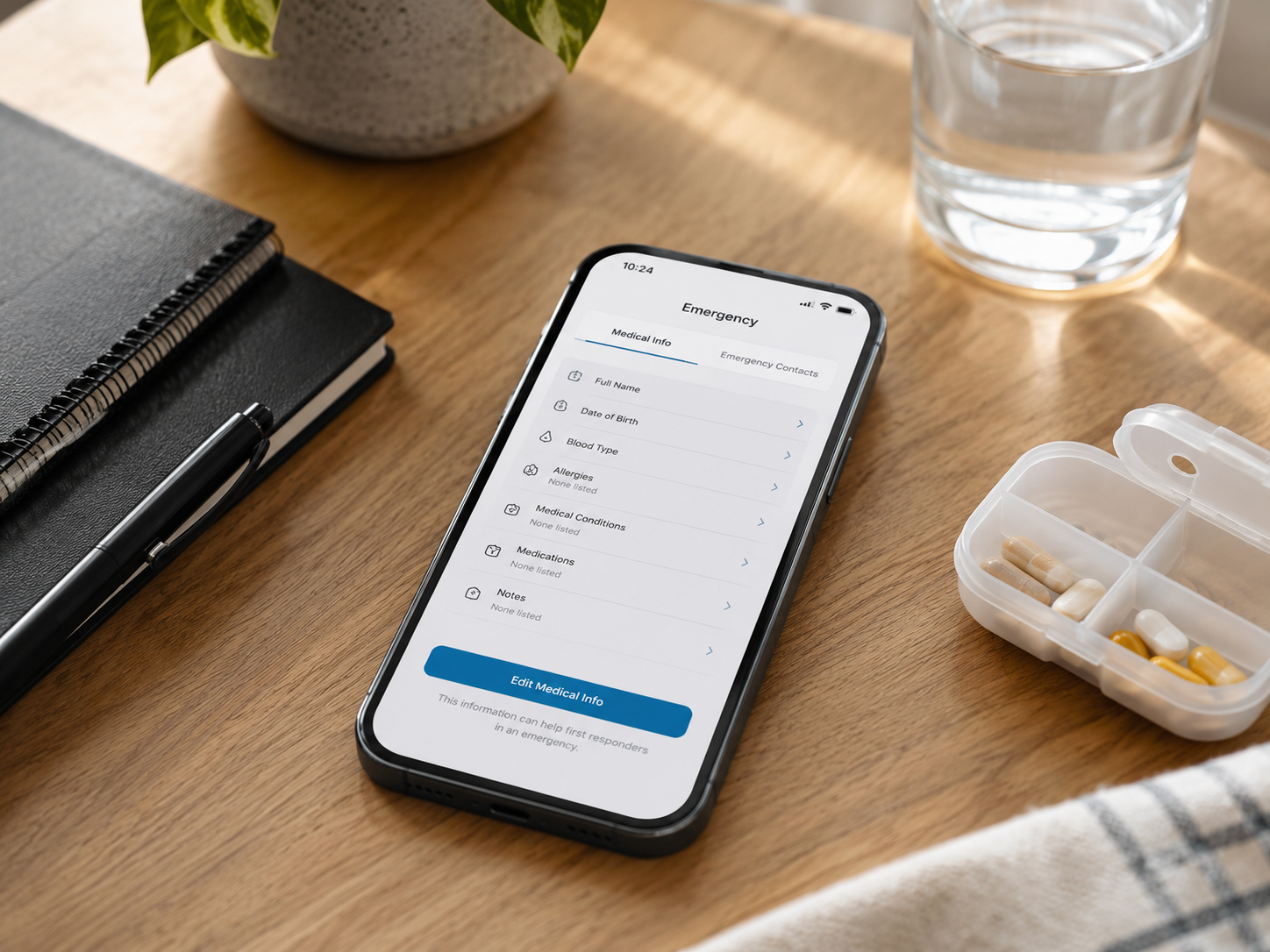 A smartphone showing emergency medical information beside a notebook and a small medicine container.